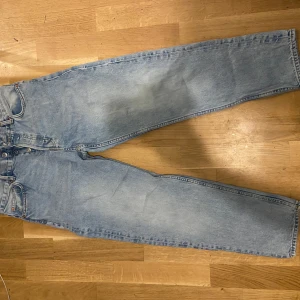 Ljusblå raka jeans i klassisk modell - Säljer ett par ljusblå jeans med rak passform och klassisk femficksdesign. Jeansen har hög midja och är tillverkade i robust denim. Perfekta för dig som gillar en tidlös och avslappnad stil.