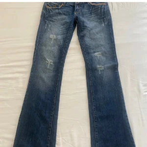 blåa only jeans - Snygga blå jeans med bootcut-modell och slitna detaljer framtill. Bakfickorna har dekorativa knappar. Aldrig använda, köpta här på plick. Säljer pågrund av att de inte passade mig.