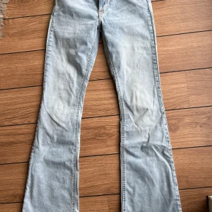 Ljusblå bootcut jeans från Gina Tricot - Säljer ett par ljusblå bootcut jeans från Gina Tricot, modell Perfect Jeans. De har klassisk femficksdesign, normal passform över låren och utsvängda ben. Jeansen är i mjuk denim med snygg tvätt och detaljerade sömmar.