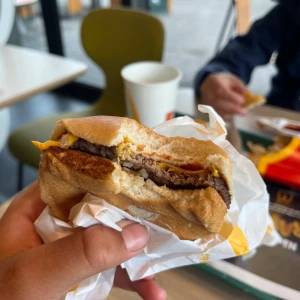 Cheeseburgare  - Bilderna visar en cheeseburgare från en snabbmatsrestaurang, inslagen i papper och delvis uppäten. pappret runt cheeseburgaren följer med och original box