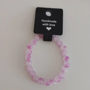 Handgjort Lila  pärlarmband -  handgjort armband med runda pärlor i olika nyanser av ljuslila och vitt. Perfekt accessoar för att ge din outfit en söt och personlig touch. Elastiskt band gör det enkelt att ta på och av. Har även i många olika färger skriv gärna för fler bilder eller frågor.