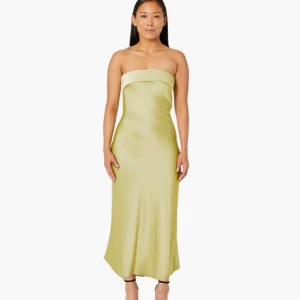 Ljusgul axelbandslös satinklänning - Säljer en ljusgul långklänning i satin med axelbandslös design och öppen rygg. Klänningen har en snygg, slimmad passform och faller mjukt längs kroppen. Perfekt för dig som vill sticka ut med en elegant och modern look.