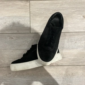 Svarta sneakers från Axel Arigato - Hej, tack för du kollar på min annons😊Stilrena svarta sneakers från Axel Arigato med ovandel i mocka och klassisk vit platt sula. Skorna har snörning och diskret logga på sidan. Perfekta för dig som gillar minimalistisk och clean streetstyle.vi säljer bara nytt men denna vill vi bara få bort så det uppskattas om du köper