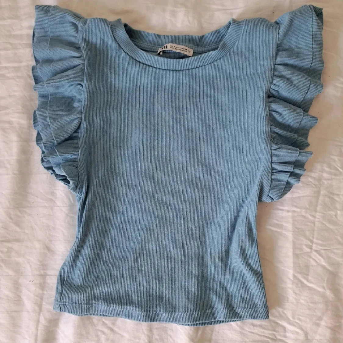 Blå ribbad topp med volangärmar