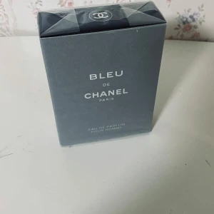 Bleu de Chanel Eau de Parfum - Bleu de Chanel Eau de Parfum Pour Homme i elegant mörkblå kartong med tydlig Chanel-logga på toppen. Parfymen är för herrar och kommer i en stilren, fyrkantig förpackning med silverfärgade detaljer. Perfekt för dig som gillar exklusiva och klassiska dofter.