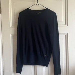 Marinblå tröja med guld detaljer från Lindex  - Marinblå tröja perfekt till hösten! Fint skick och nästan alldrig använd. Saknas en knapp på ena ärmen men det finns en extra i lappen på insidan, lätt att sy fast! 
