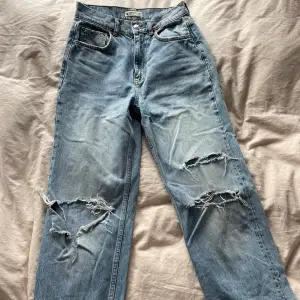 Blåa raka jeans med hål, använda men är i bra skick. Strl 34 och säljes för 90kr