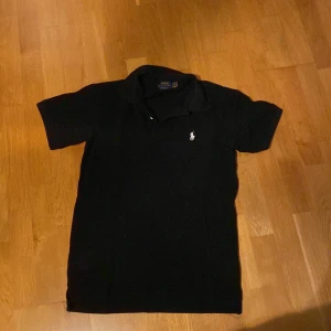 Svart ralph lauren polo tröja - Hej säljer nu min svarta polo tröja som inte är använd så mycket. Den är i storlek S men skulle passa lite slim på M.