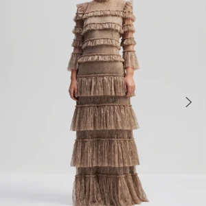 Carmine maxiklänning  - Carmine maxiklänning i greige. Använd en gång på ett bröllop och är i otroligt fint skick. Nypris 4500kr. 