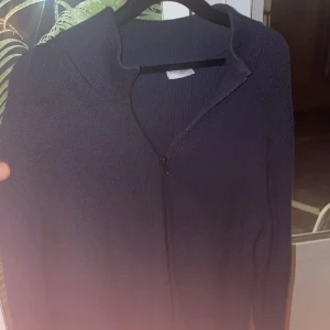 John Henric Fullzip  - Säljer en stilren svart kofta från John Henric. Den har en dragkedja framtill och är perfekt för både vardag och lite finare tillfällen. Koftan är långärmad och är en kashmir och bomullsmix. Passar perfekt till hösten och vintern!