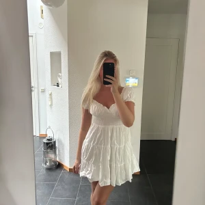 Vit klänning - Vit klänning med volang och urringning😘