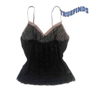 Svart spetslinne med rosa detaljer - svart spetslinne med tunna axelband och vacker rosa spetskant. Linnet har ett blommigt mönster och en liten rosett. Fins ett litet hål (kolla bilden)