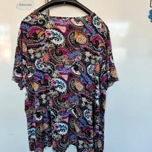 Färgglad mönstrad topp - Säljer en färgglad topp med ett livligt paisleymönster i lila, rosa, blå och orange nyanser. Toppen har korta ärmar och en lös passform, perfekt för en avslappnad stil. Storlekslapp är bortklippt men är 52-54. 