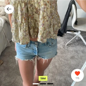 Blå jeansshorts - Snygga blå jeansshorts med råa kanter och en avslappnad look. Perfekta för varma sommardagar. De har en klassisk femficksdesign och knappgylf. Köpta på Plick, men säljer då de inte passar längre!