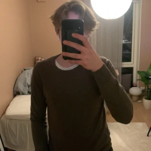 Brun tröja från J.Lindeberg - Säljer en stilren brun tröja från J.Lindeberg. Tröjan har en rund halsringning och är tillverkad i ett mjukt material. Lite sönder där bak kan diskutera om priset om det är viktigt.