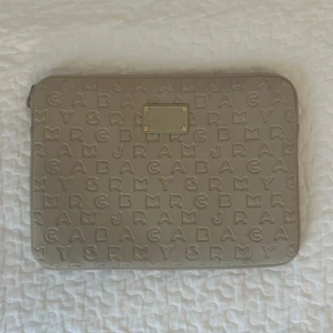 Beige datorfodral Marc Jacobs - Snygg beige datorväska från Marc by Marc Jacobs . Lite smutsig på vissa ställen men märks ej vid användning, se bild. 