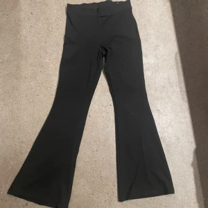 Svarta bootcut byxor från Gina Tricot - Snygga svarta bootcut byxor från Gina Tricot. De är högmidjade och har en stilren design som passar perfekt till olika tillfällen. Byxorna är tillverkade i ett mjukt och bekvämt material.