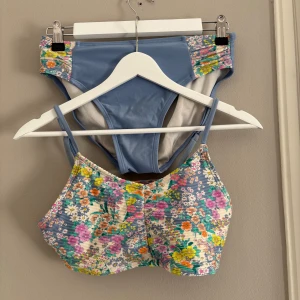 Bikini med ribbad topp - Snygg bikini med blommigt mönster i storlek S. Toppen har smala axelband med ribbad struktur. . Perfekt för sommaren. 