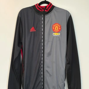 Retro Manchester United Jacka  - Snygg retro Manchester United jacka från Adidas. Jackan har dragkedja och broderad logga på bröstet samt rygg.