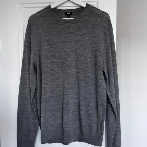 Grå tröja från Uniqlo - Säljer en stilren grå tröja från Uniqlo. Tröjan är långärmad och har en klassisk rund halsringning. Perfekt för en minimalistisk look. Tillverkad i ett mjukt material som känns skönt mot huden. Hör av dig vid minsta fråga eller fundering!