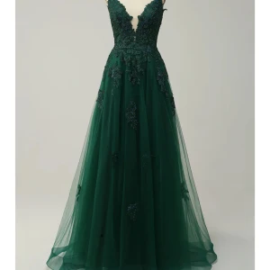 Grön balklänning med spetsdetaljer - Elegant grön långklänning med v-ringad fram och öppen rygg. Klänningen har vackra spetsdetaljer och smala axelband som korsas i ryggen. Jag har endast använt den en gång så den är så gott som ny! Den är i storlek 40 men passar mellan 36-42 då den knyts i ryggen. Dessutom är den uppsydd och passar bra för någon som är mellan 165-175 med klackar! Köpt för 1700kr och är som sagt i perfekt skick. Klänningen är perfekt för dig som har bal snart eller bara vill ha en extra vacker klänning hemma!