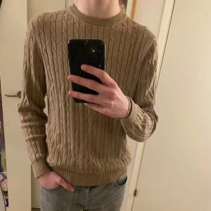 Beige stickad tröja från Bondelid - Säljer en snygg beige stickad tröja från Bondelid med klassiskt flätmönster. Tröjan har använts endast 1 gång och är i mycket fint skick har inga fläckar eller märken.