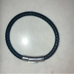 Svart flätat armband - Snyggt svart flätat armband med en stilren silverfärgad låsdetalj. Perfekt för både vardag och fest! Armbandet är cirka 6 cm långt och passar de flesta handleder. Enkelt att matcha med andra smycken eller klockor.