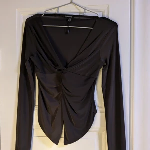 Knuten tröja - FRAKTEN ÄR INRÄKNAD I PRISET  Mörkbrun/svart( syns i vissa ljus),urringad,bra längd i armarna,luftigt material.  Har aldrig använt den