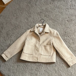 En kappa/jacka från lager 157 i färgen beige  - Storlek 140 använd få tal gånger perfekt för höst och vår