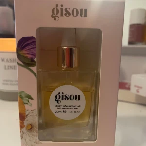Gisou Honey Infused Hair Oil - Säljer en lyxig hårprodukt från Gisou, deras Honey Infused Hair Oil. Den kommer i en elegant glasflaska på 20 ml. Men har använt 1 tredje del. Oljan är berikad med honung för att ge näring och glans till håret. Perfekt för alla hårtyper och kan användas både i torrt och fuktigt hår. En måste-ha för att bekämpa friss och skydda mot fukt.