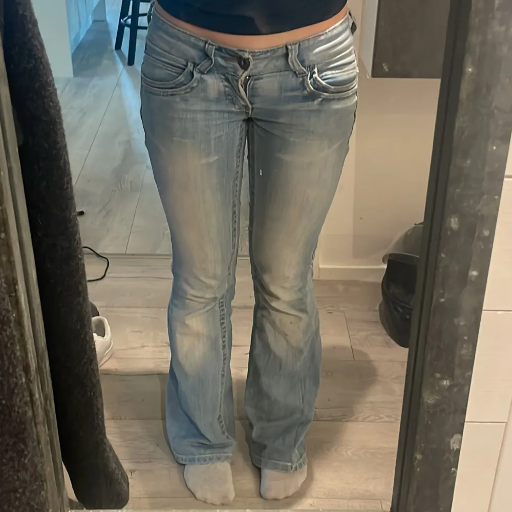 Säljer ett par ljusblå bootcut jeans i bra skick. De är lågmidjade och har en slitning på baksidan men som jag har fixat och som man inte tänker. Skriv om ni har några frågor💗 innerbenslängden är 80cm och midjemåttet mätt rätt över är 37cm. Jeans & Byxor.