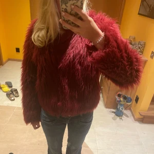 Röd pälsjacka - Säljer denna superfina röda/vinröda pälsjacka från BikBok perfekt nu till hösten/vintern. Varm och gosig!❤️pris kan diskuteras! (Fakepäls såklart)