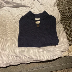 Mörkblå stickad tröja från Pier One - Säljer en snygg mörkblå stickad tröja från Pier One. Tröjan har en dragkedja vid halsen och långa ärmar. Perfekt för kyligare dagar.