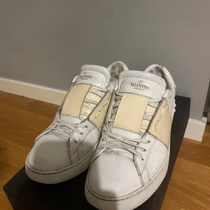 Valentino Garavani sneakers i vitt och beige - Snygga Valentino Garavani sneakers i vitt med beige detaljer. Skorna har hyfsat skick, dom e använda men har mycket kvar att ge. 100% äkta från vestaire collective alltså äkthets checkad av proffs ‼️Skriv innan ni köper‼️