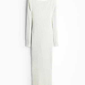Vit ribbad långklänning - Elegant vit ribbad långklänning med långärmad design. Perfekt för en stilren look med sin enkla och tidlösa stil. Klänningen har en smickrande passform som framhäver figuren. Lappar kvar, helt ny!