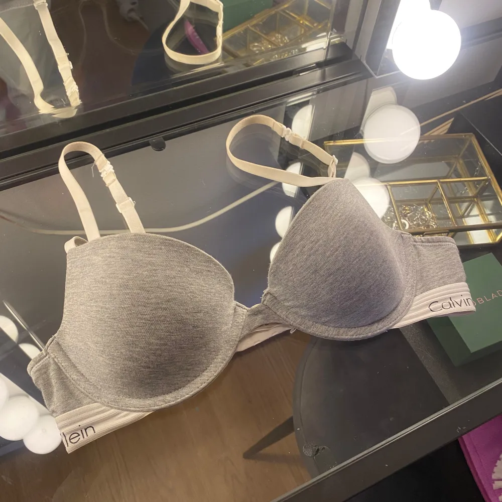 Säljer en stilren grå bh från Calvin Klein med justerbara axelband och mjuka kupor även kmäppen som gör att man kan ha banen i ett kryss över ryggen. Väldigt snygg och skön, tyvärr lite liten till mig :(. Yläosat.