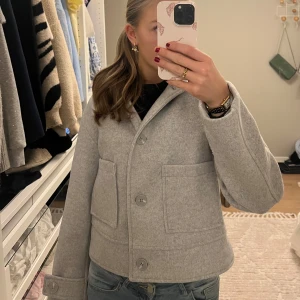 Grå kappa från 157 - Säljer en stilren och slutsåld grå kappa från 157 i storlek XS. Jackan har en klassisk design med stora knappar och två framfickor. Perfekt vår/höstjacka🍁🌸Nästan aldrig använt och är i jättebra skick.