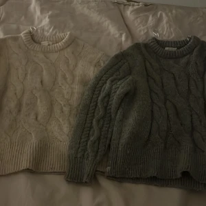 2 för 450! - Två mysiga stickade tröjor från Gina Tricot i storlek 146/152. Den ena är beige och den andra grå, båda med ett flätmönster. Även 2 för 450 just nu så passa på! 