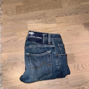 Blå jeans från Jacob Cohen - Snygga blå jeans från Jacob Cohen med slim passform. De har klassiska fem fickor och knappar i gylfen. Perfekta för en stilren look.
