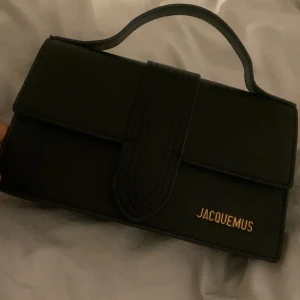 Svart handväska från Jacquemus - Snygg svart handväska Jacquemus. Väskan har ett handtag och en avtagbar axelrem för flexibilitet.