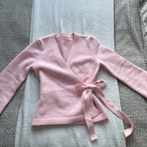 Rosa kofta - Säljer en söt rosa omlottkofta med knytband i midjan. Okänt vart den är ifrån, då det var en present. Storlek s men skulle även passa m