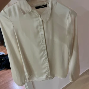 En satin skjorta. Har haft på mig den en gång  - Det är en vid/begie skjorta som jag har haft på mig den en gång. Skicket är bra inga skador eller fläckar på dene 