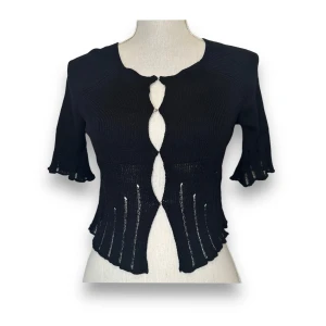 Svart kortärmad kofta från ASOS DESIGN - En snygg svart kortärmad kofta från ASOS DESIGN. Den är stickad och har en unik design med hålmönster och källor framtill. Perfekt för både vardag och fest! 🖤