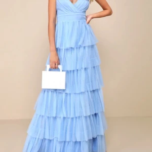 En ljusblå balklänning med volanger från Lulus i storlek xs -  Storlek xs, passar någon som är runt 160cm lång. Är köpt för 1550kr men säljer för 1000kr pågrund av de väldigt fina skicket. Klänningen har även justerbara band så klänningen ska passa just dig. Endast använd en gång! 