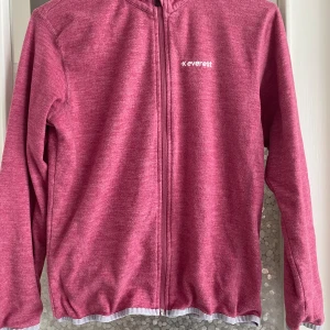 Rosa fleecejacka från Everest - Säljer en mysig rosa fleecejacka från Everest. Den har en dragkedja framtill och är långärmad. Perfekt för kyliga dagar och passar bra till både vardag och utomhusaktiviteter. Jackan är i bra skick och redo för en ny ägare!
