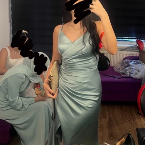 Mintgrön/blå lång satin klänning -  Använd endast en gång utan några skador, den är stl 40 men väldigt liten i storlek så passar även 36/38, passar som balklänning men i mitt fall var det en brudtärna klänning. (Kan skicka tydligare bilder vid intresse)