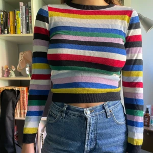 Randig tröja från monki - Superfin färgglad tröja från monki. Några av ränderna är i glittrigt tyg. Tröjan är i fint skick, har använts en del men har inga skavanker. Säljer då den är lite tajt på mig och inte kommer till användning så ofta längre. 
