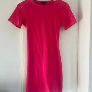 Rosa kortklänning med öppen rygg - En rosa kort åtsittande klänning ifrån Monki. Endast använd vid ett tillfälle och har ett väldigt skönt material. Knyterna i ryggen är justerbara och klänningen är en S. 