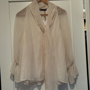 Blus från Zara - Jättefin tunn knytblus från Zara.  Helt oanvänd, lappen sitter kvar. Undertyg över mage/rygg. Storlek: S. 