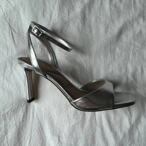 Silvriga sandaler  - Silvriga sandaler, nyköpta endast använda en gång. Gjorda på 99% Polyuretan. Säljer då dem inte används. 